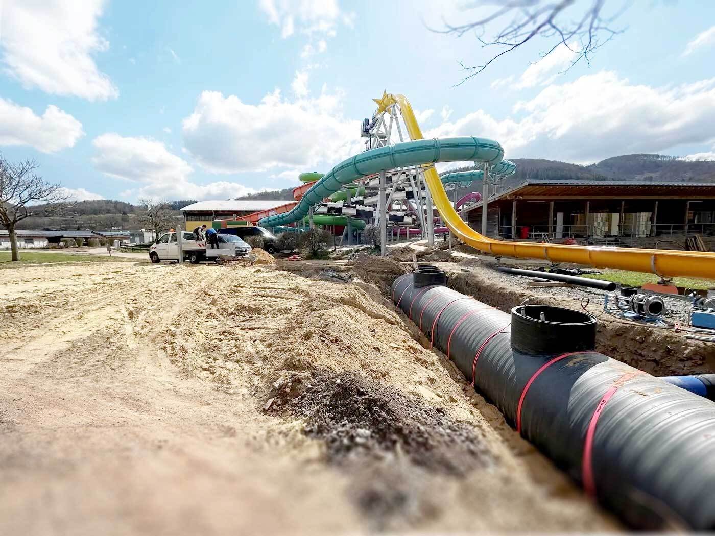 Schwallwasserbehälter aus HDPE im Rohrgraben, darüber die Rutsche des Magnus Freizeitbads Plettenberg.